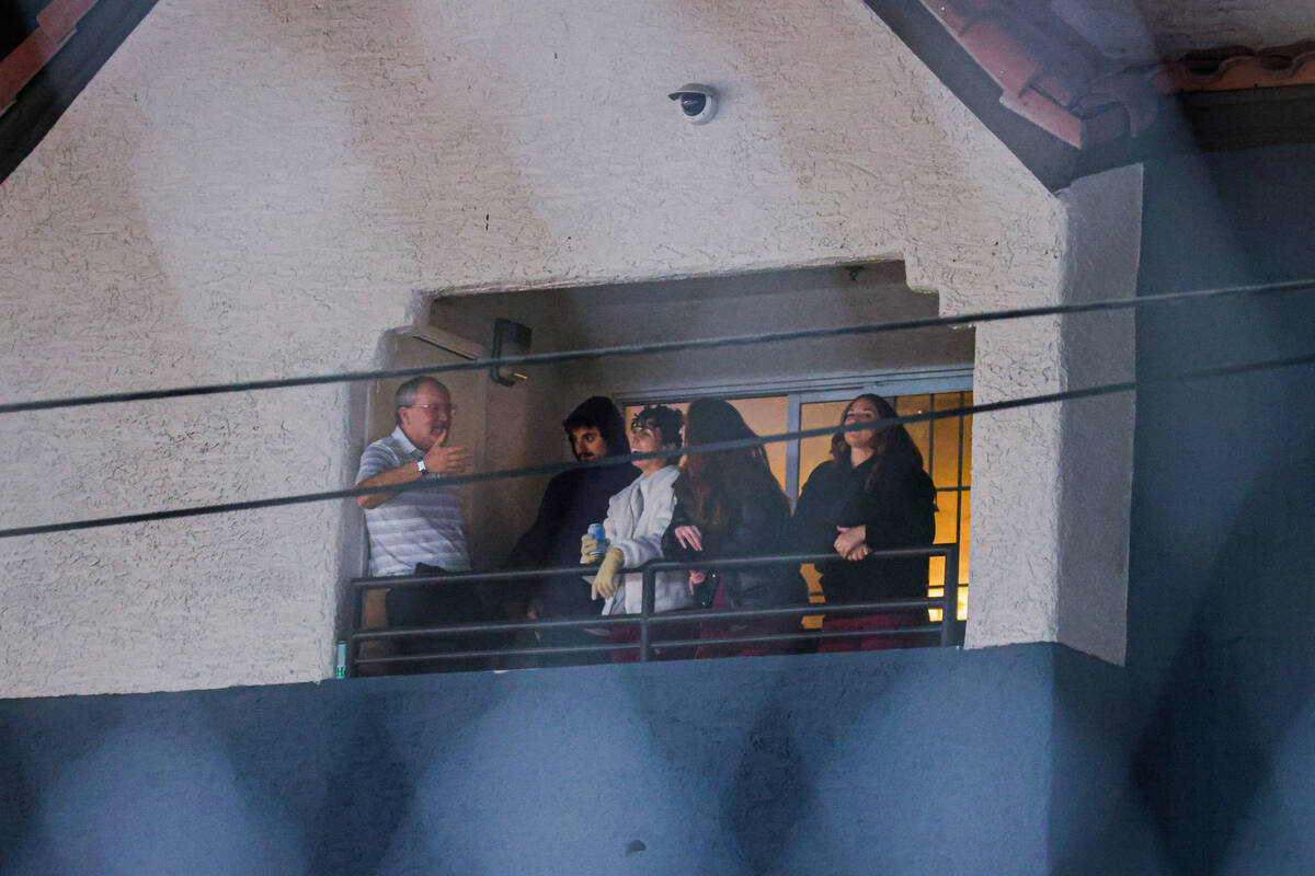 Spectators watch Formula 1 drivers race the circuit from an apartment complex during the second ...