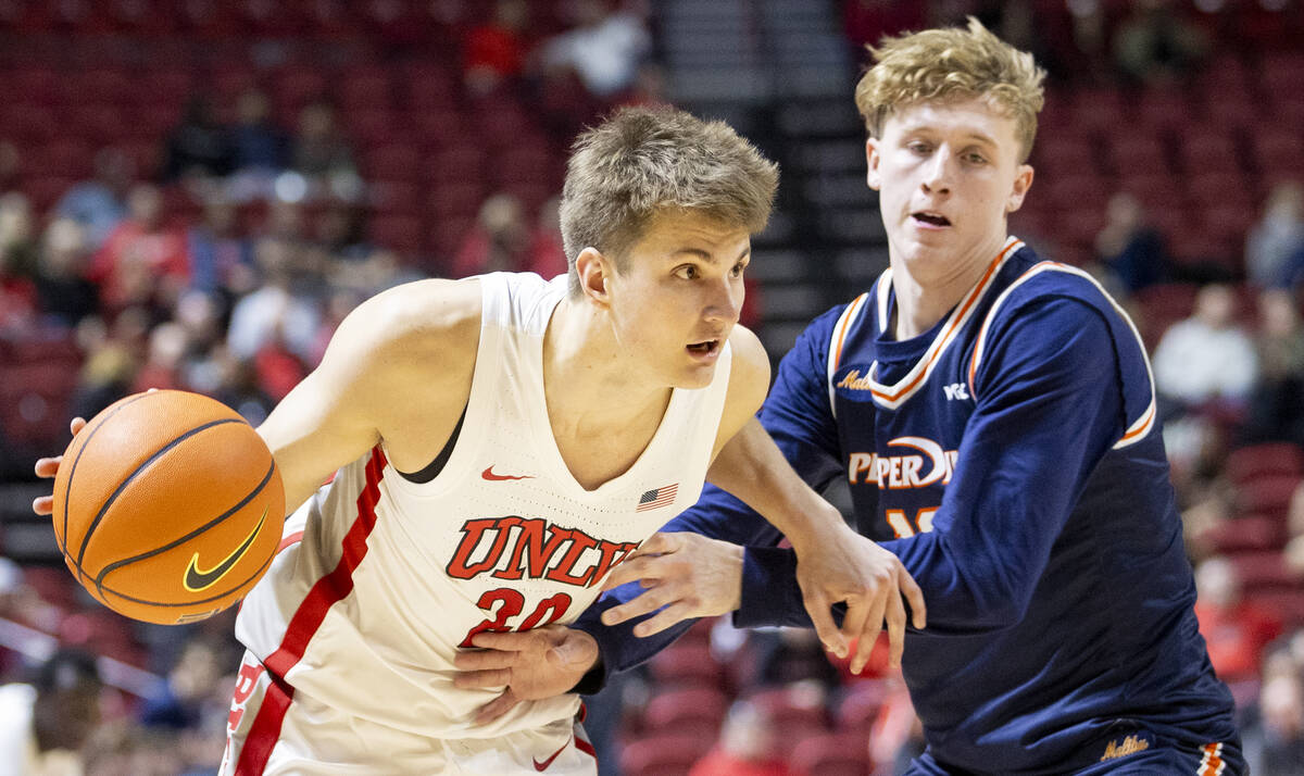 UNLV guard Julian Rishwain (20) attempts to dribble around Pepperdine Waves guard Jaxon Olvera, ...