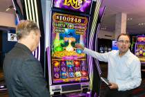 Nick Khin, right, a COO of Gaming for IGT, demonstrates how Mystery of the Lamp game is played ...