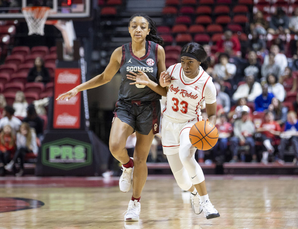 UNLV guard Amarachi Kimpson (33) attempts to run around Oklahoma Sooners guard Zya Vann, left, ...