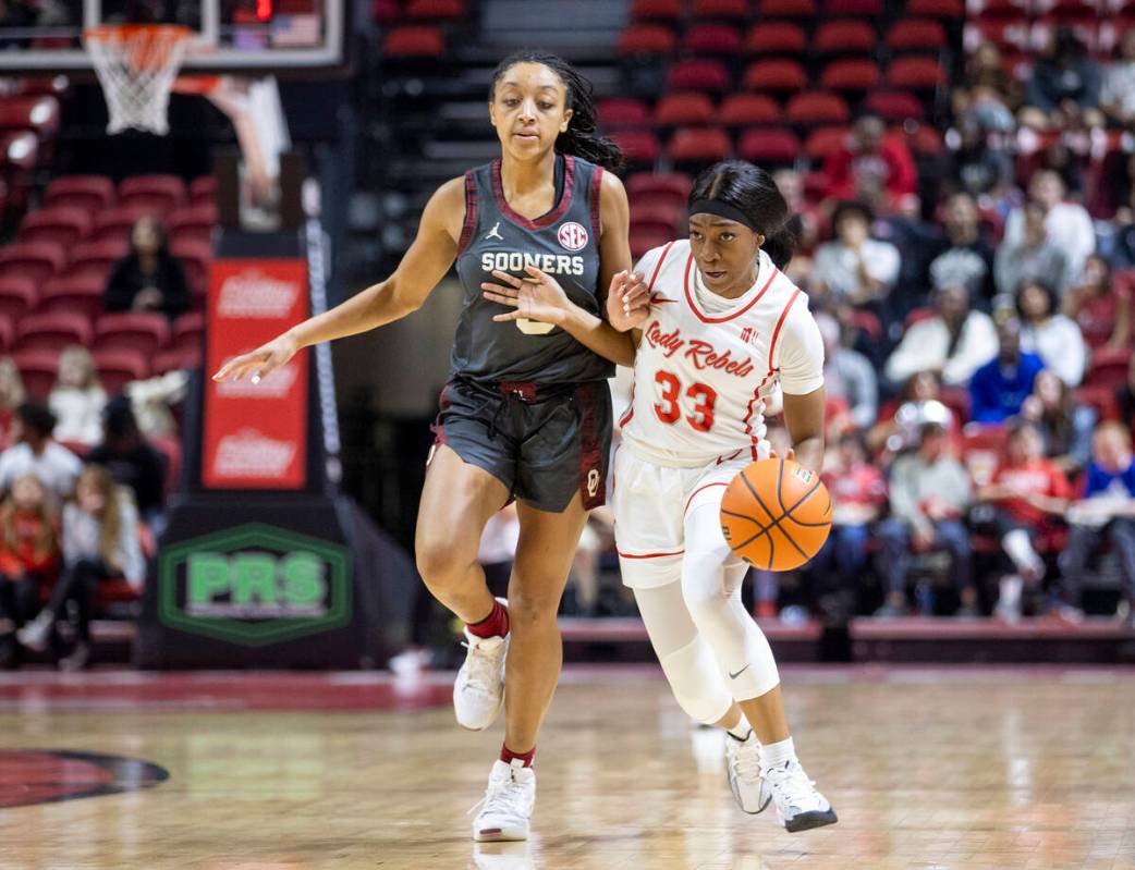 UNLV guard Amarachi Kimpson (33) attempts to run around Oklahoma Sooners guard Zya Vann, left, ...