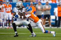 Raiders wide receiver Jakobi Meyers (16) makes a catch with Denver Broncos cornerback Ja'Quan M ...