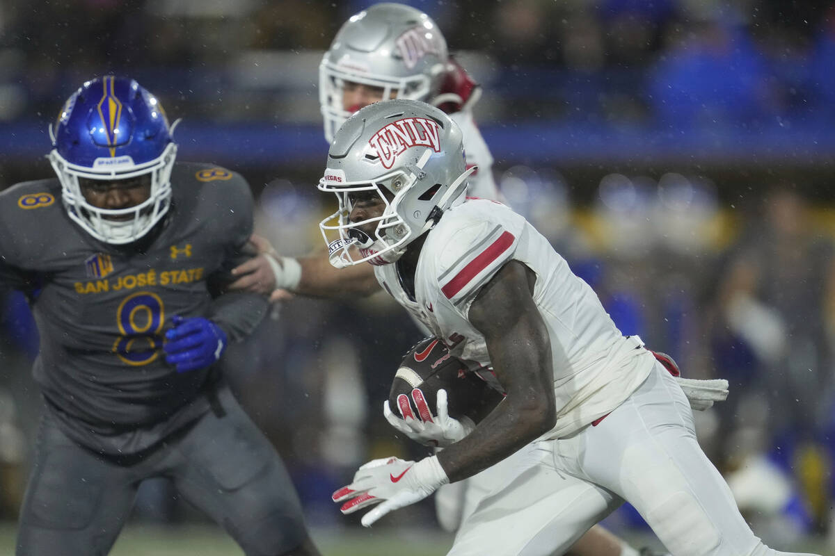 UNLV running back Jai'Den Thomas, right, runs the ball during the first half of an NCAA college ...