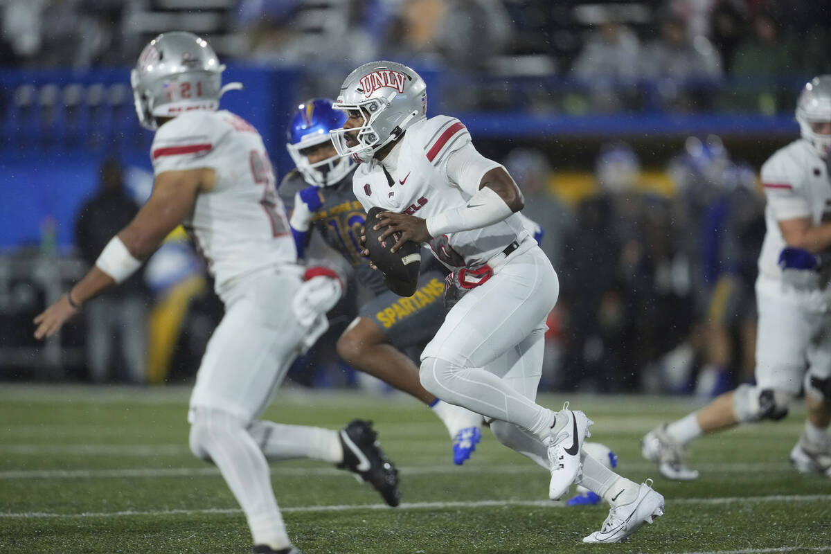 UNLV quarterback Hajj-Malik Williams, center, runs the ball during the first half of an NCAA co ...