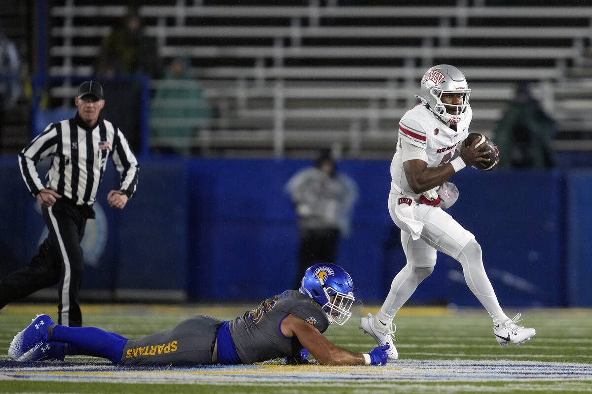 UNLV quarterback Hajj-Malik Williams, right, evades pressure from San Jose State linebacker Joh ...