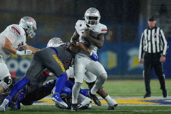 UNLV running back Jai'Den Thomas, right, is tackled by San Jose State linebacker John Ward duri ...