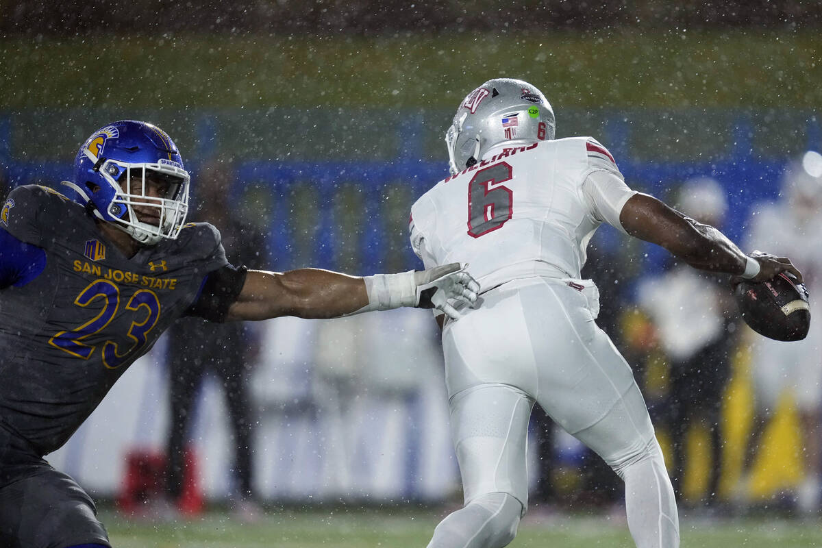 UNLV quarterback Hajj-Malik Williams, right, evades pressure from San Jose State defensive line ...