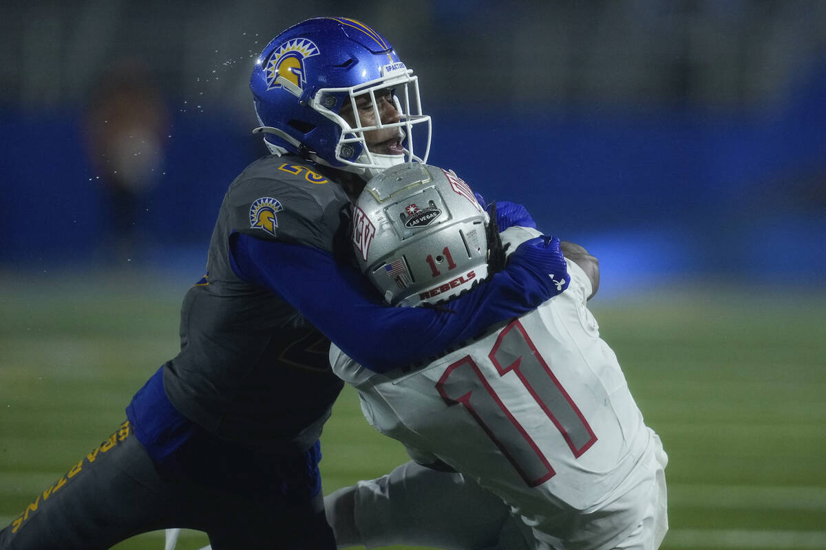 San Jose State defensive back Michael Dansby, left, tackles UNLV wide receiver Ricky White III ...