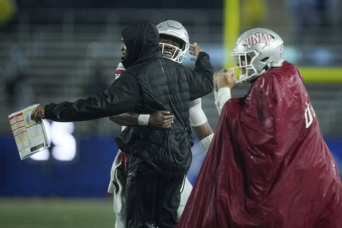 UNLV quarterback Hajj-Malik Williams, second from left, celebrates with a member of the staff d ...