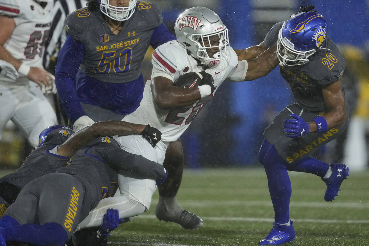 UNLV running back Kylin James, center, runs the ball against San Jose State defensive back Isia ...