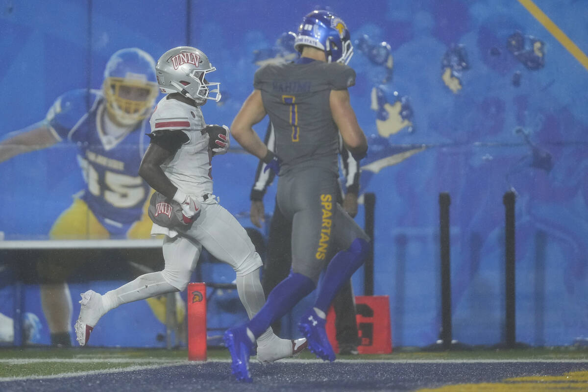 UNLV running back Jai'Den Thomas, left, scores a touchdown against San Jose State during the se ...