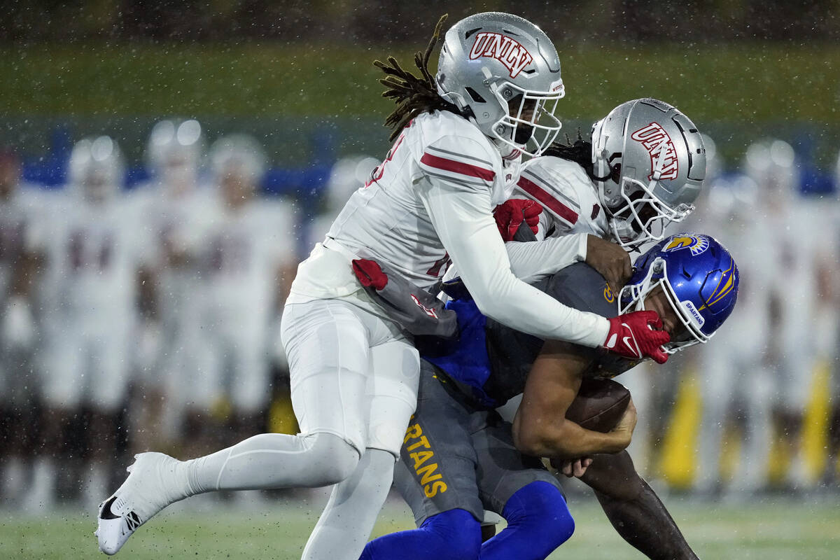 San Jose State wide receiver Nick Nash, right, is tackled by UNLV defensive backs Jarvis Ware, ...