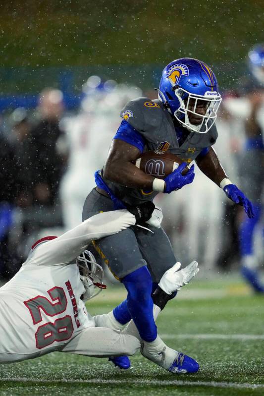 San Jose State running back Jabari Bates, right, is tackled by UNLV defensive lineman Fisher Ca ...