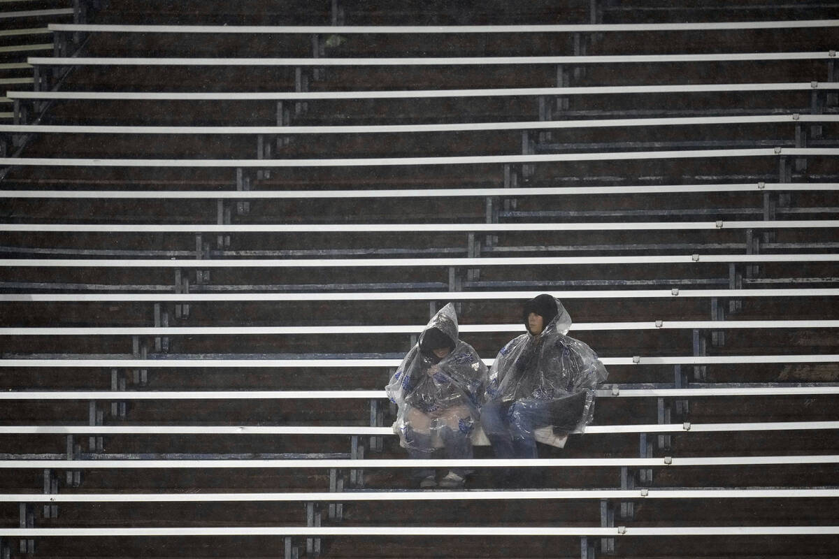 Fans sit in the rain while watching the first half of an NCAA college football game between San ...