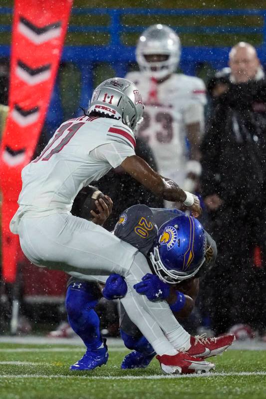 San Jose State defensive back Isiah Revis (20) tackles UNLV wide receiver Ricky White III (11) ...