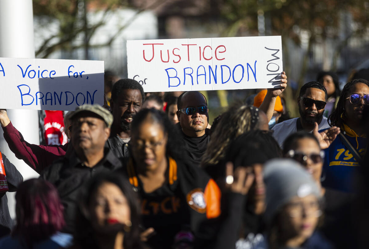 Carlos Garcia holds up a sign during a rally for Brandon Durham, who was shot and killed by pol ...