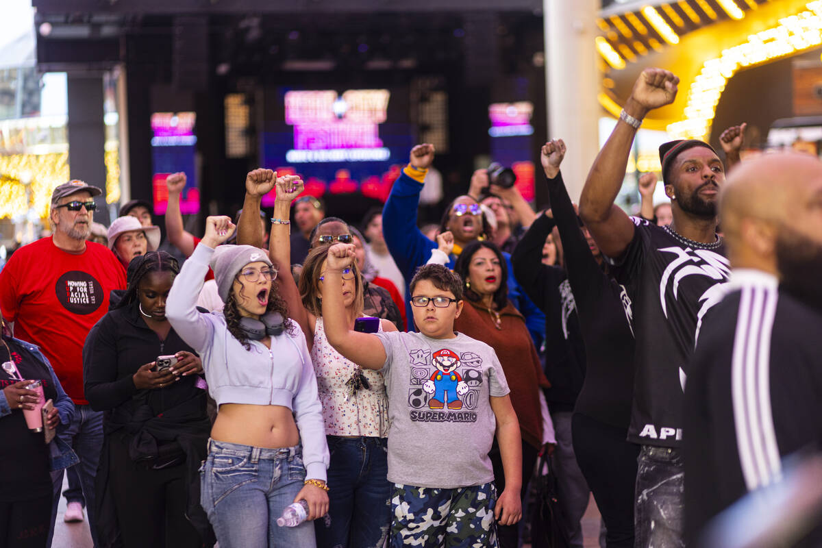 People march along the Fremont Street Experience during a rally for Brandon Durham, who was sho ...