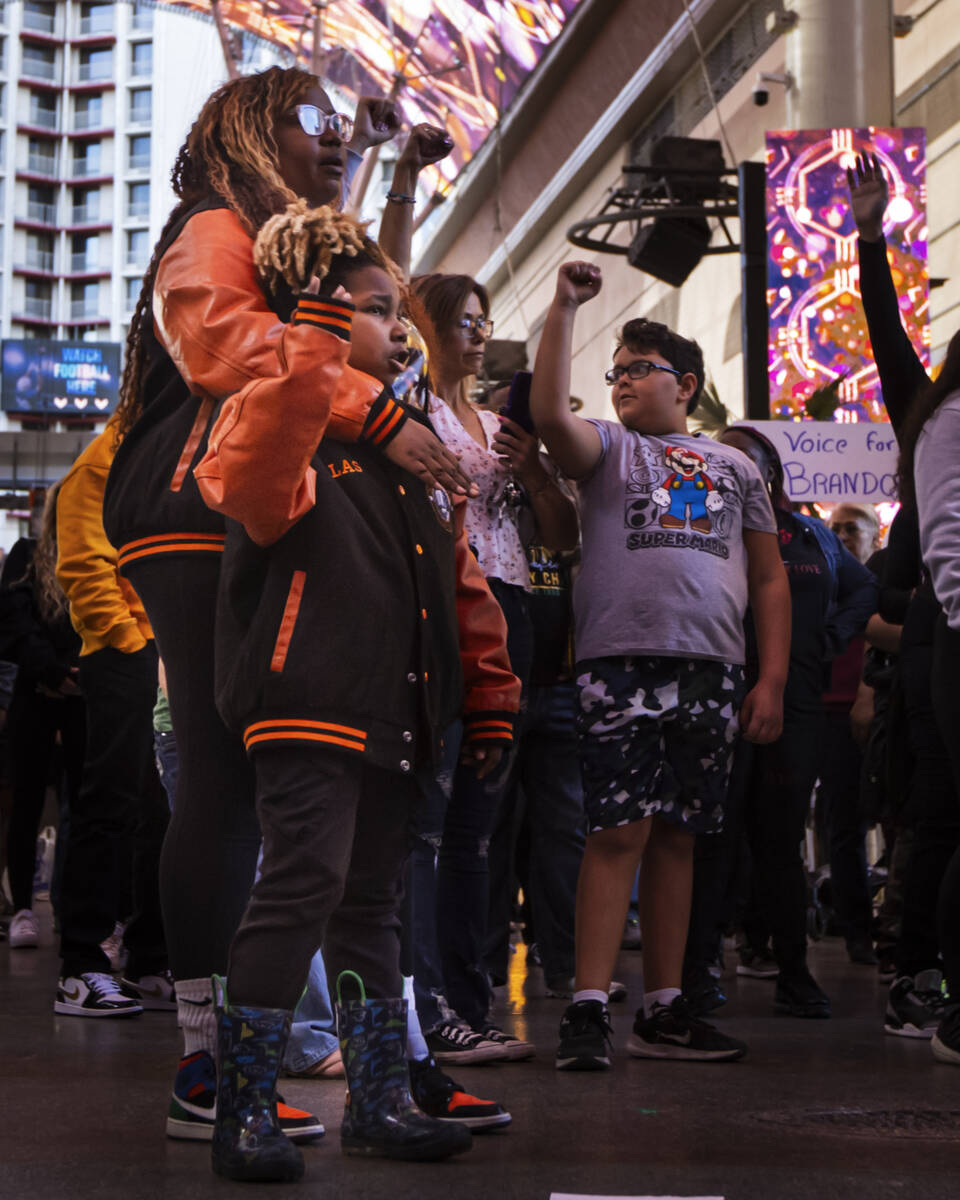 People participate in a march along the Fremont Street Experience following a rally for Brandon ...