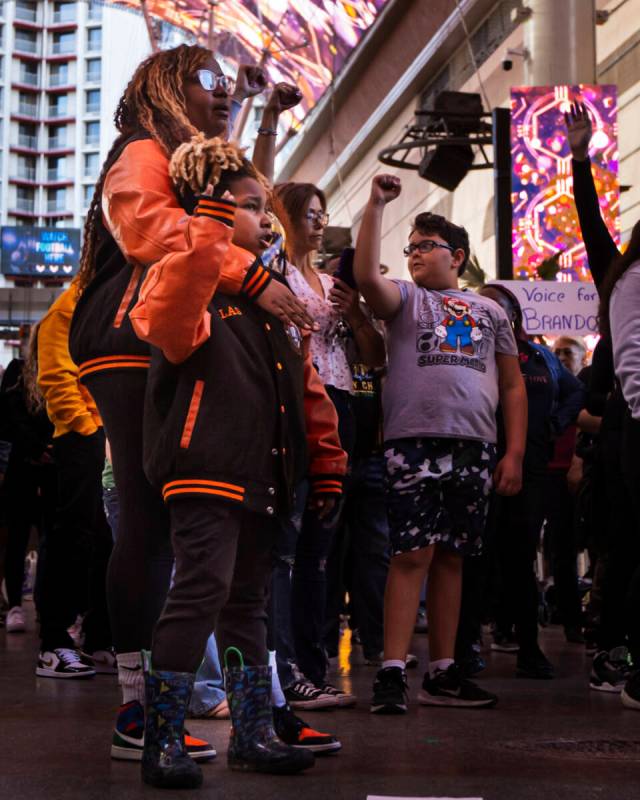 People participate in a march along the Fremont Street Experience following a rally for Brandon ...