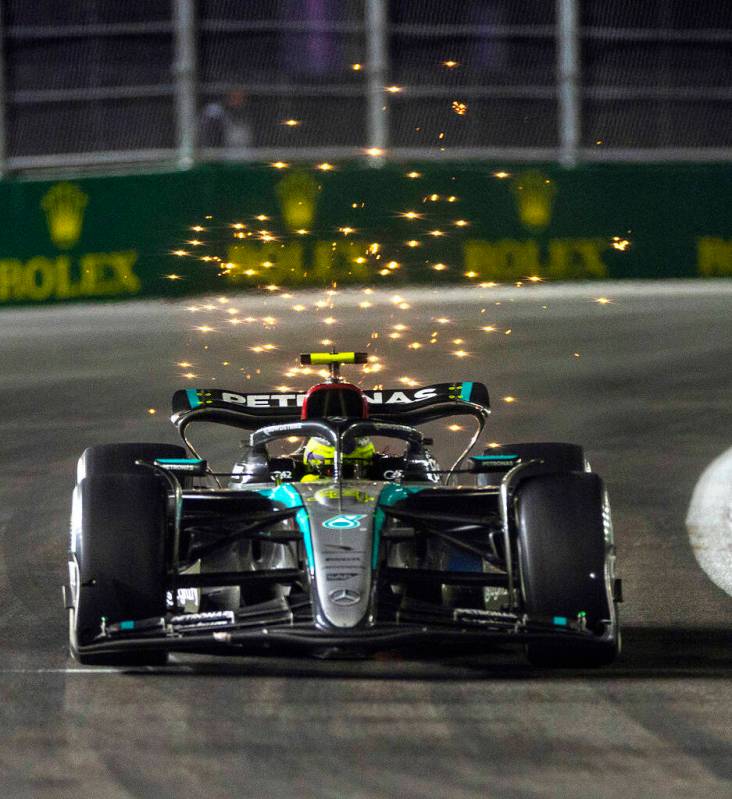 Mercedes driver Lewis Hamilton sends some sparks flying while in the final turn on the track du ...