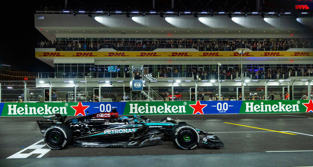 Mercedes driver George Russell crosses the finish line as the flag waves in the tower winning t ...