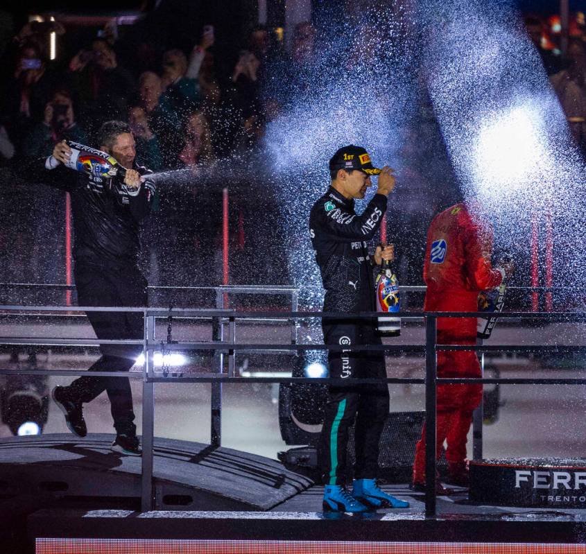 Mercedes driver George Russell and Ferrari driver Carlos Sainz are sprayed sprayed with champag ...