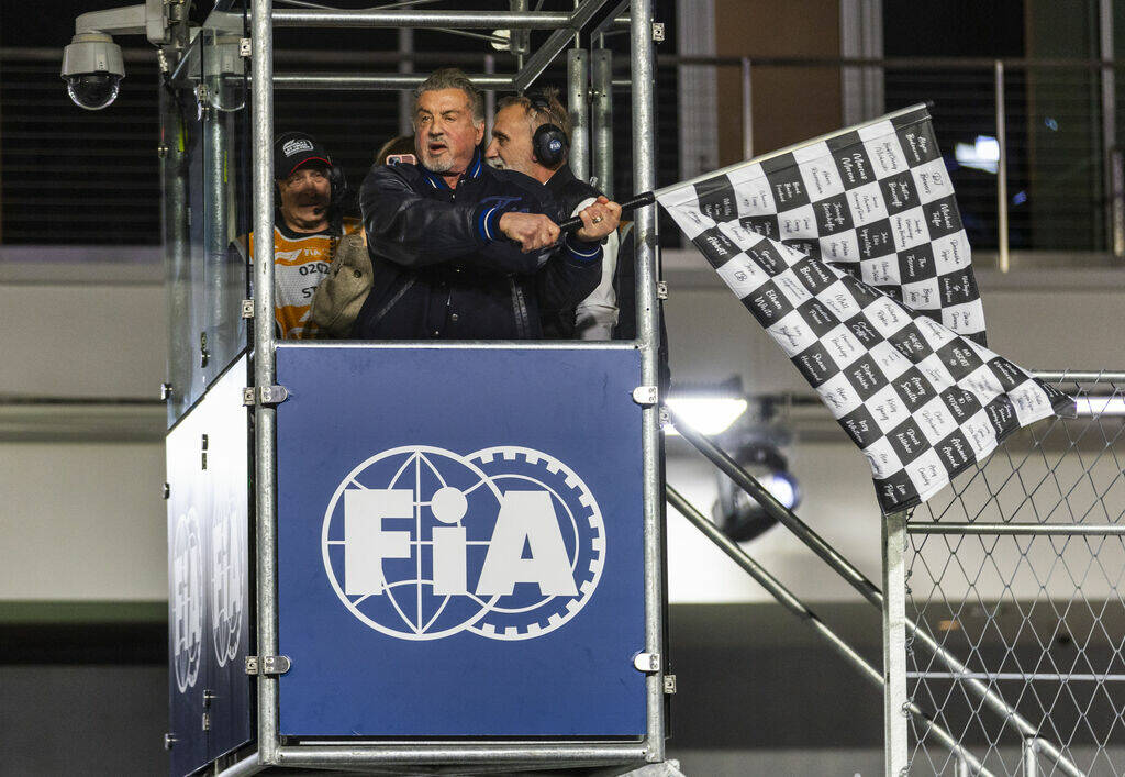 Actor Sylvester Stallone waves the checkered flag at the finish line as the race concludes at t ...