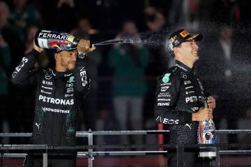 Mercedes driver Lewis Hamilton, of Britain, left, sprays champagne on race winner Mercedes driv ...