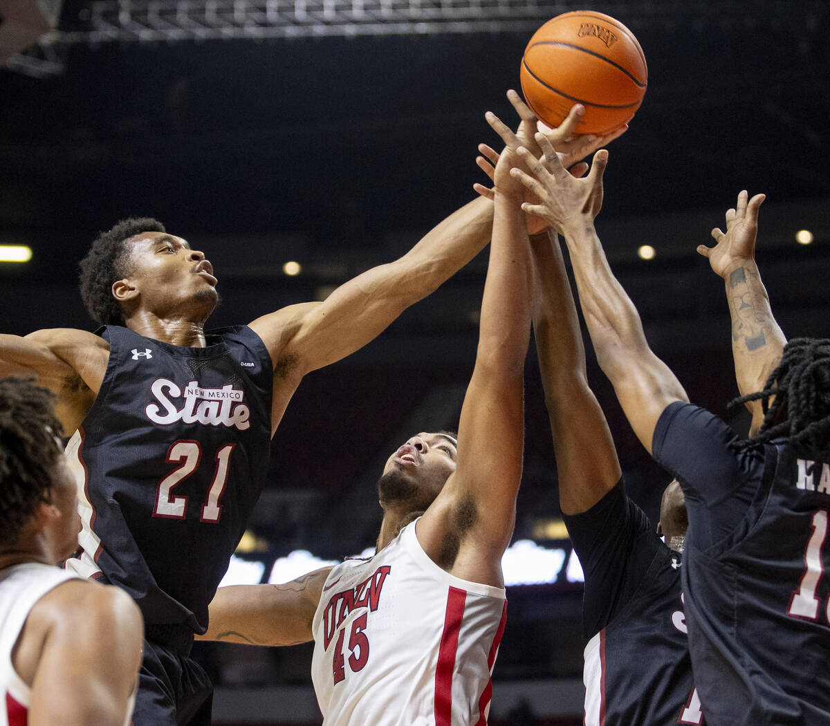 UNLV forward Jeremiah Cherry (45) attempts to rebound the ball from a pack of New Mexico State ...