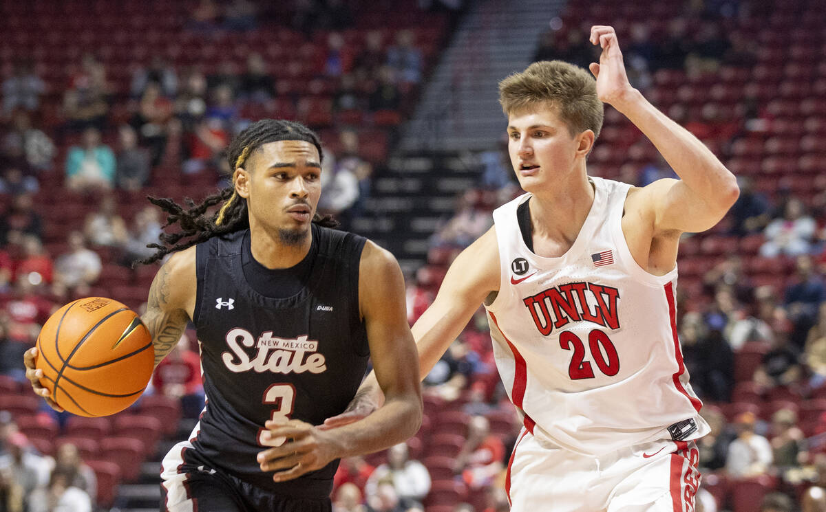 UNLV guard Julian Rishwain (20) guards New Mexico State Aggies guard Christian Cook (3) during ...