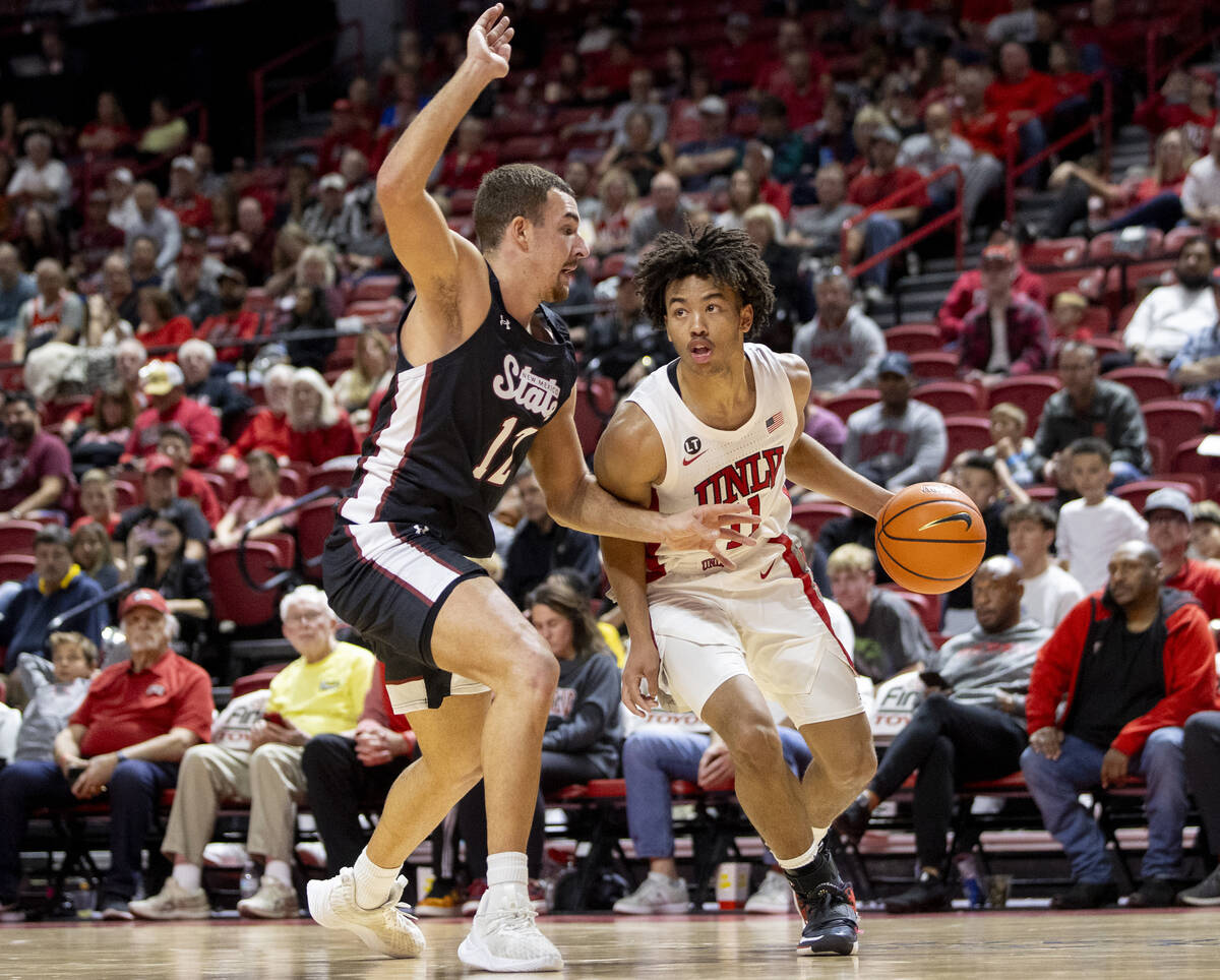 UNLV guard Dedan Thomas Jr. (11) competes against New Mexico State Aggies forward Peter Filipov ...