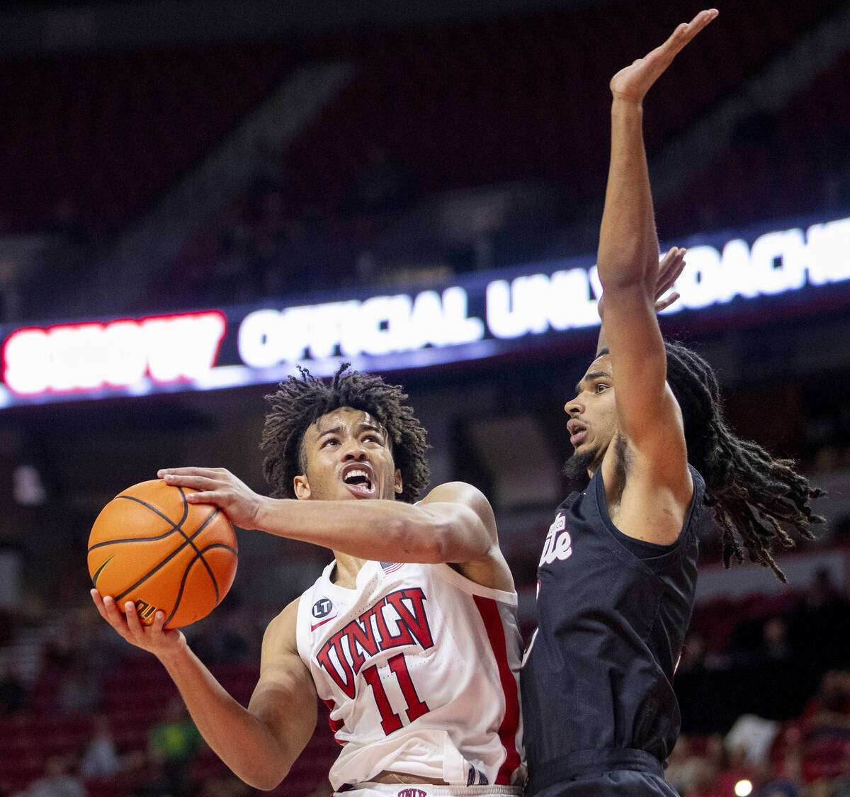 UNLV guard Dedan Thomas Jr. (11) attempts to shoot a layup past New Mexico State Aggies guard C ...