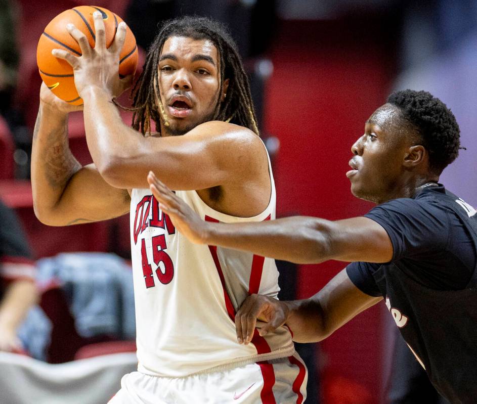 UNLV forward Jeremiah Cherry (45) is guarded by New Mexico State Aggies forward Nate Tshimanga, ...