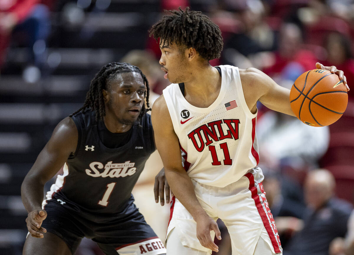 UNLV guard Dedan Thomas Jr. (11) looks to make a play against New Mexico State Aggies guard Gab ...