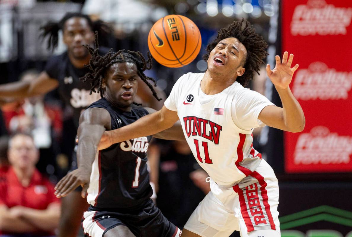 UNLV guard Dedan Thomas Jr. (11) is fouled by New Mexico State Aggies guard Gabe Pickens (1) du ...