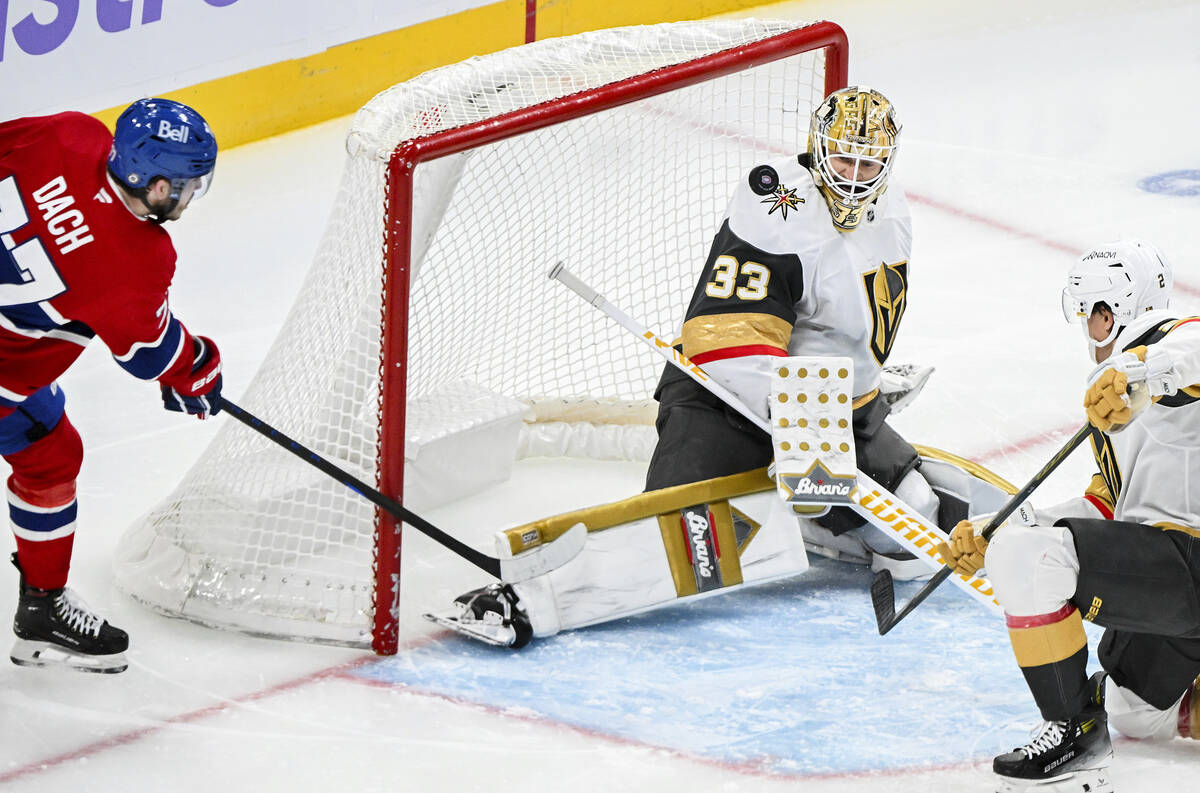 Montreal Canadiens' Kirby Dach (77) moves in on Vegas Golden Knights goaltender Adin Hill (33) ...