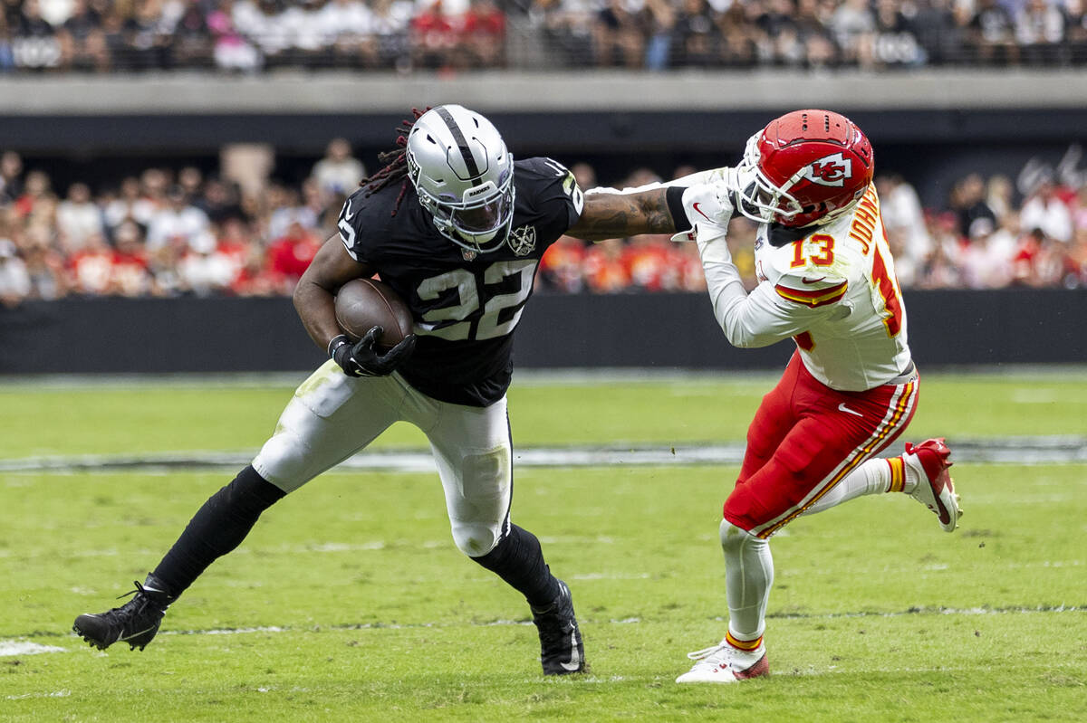 Raiders running back Alexander Mattison (22) fends off Kansas City Chiefs safety Nazeeh Johnson ...