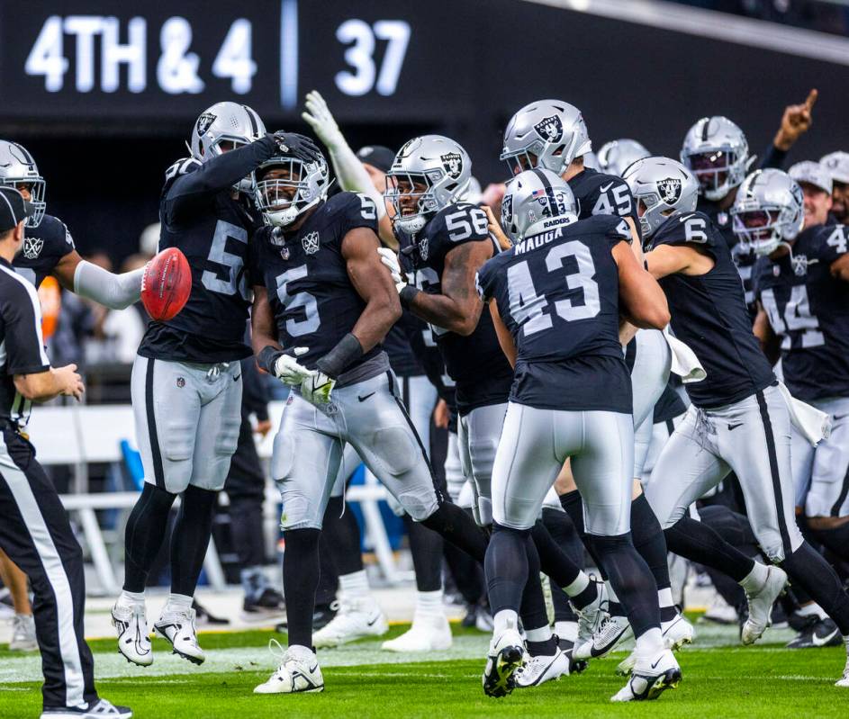 Raiders teammates celebrate linebacker Divine Deablo (5) after a fake punt pass reception and r ...