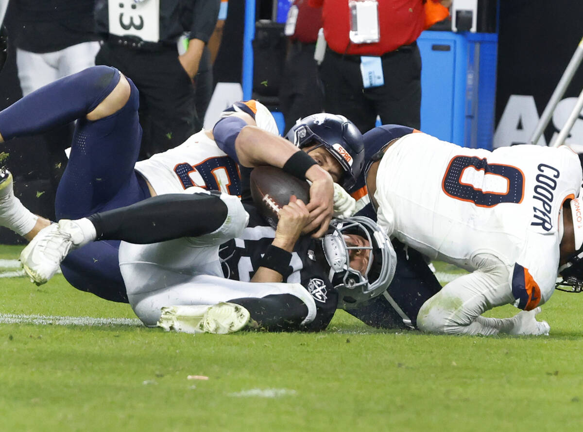 Raiders quarterback Gardner Minshew (15) is sacked by Denver Broncos linebacker Cody Barton (55 ...