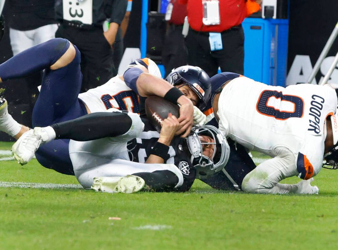 Raiders quarterback Gardner Minshew (15) is sacked by Denver Broncos linebacker Cody Barton (55 ...