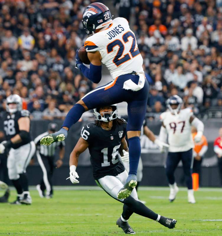 Raiders wide receiver Jakobi Meyers (16) watches as Denver Broncos safety Brandon Jones (22) in ...