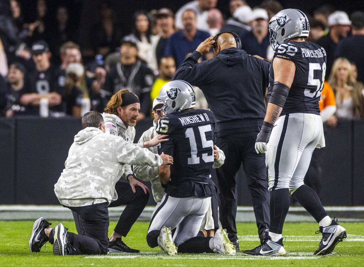 Raiders quarterback Gardner Minshew (15) is assisted after being injured during a sack by the D ...