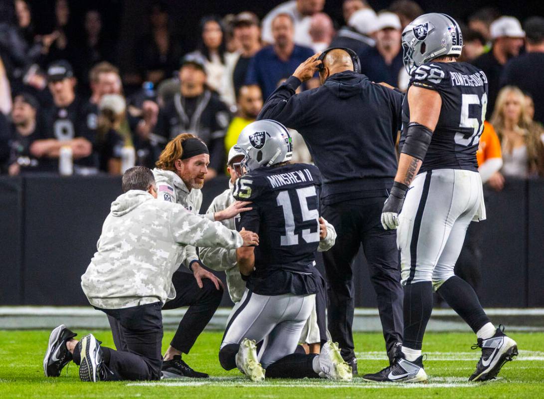 Raiders quarterback Gardner Minshew (15) is assisted after being injured during a sack by the D ...