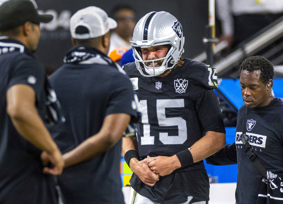 Raiders quarterback Gardner Minshew (15) exits the field after a sack led to a collarbone injur ...