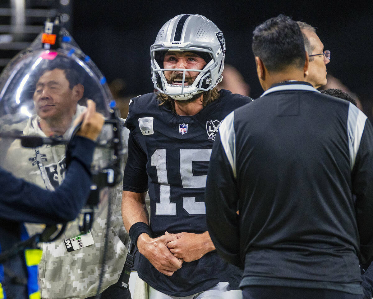 Raiders quarterback Gardner Minshew (15) exits the field after a sack led to a collarbone injur ...