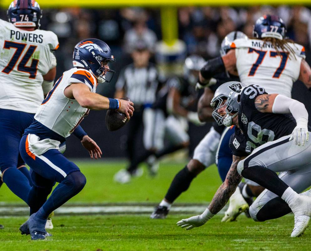 Raiders defensive end Maxx Crosby (98) cuts off Denver Broncos quarterback Bo Nix (10) causing ...