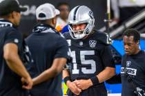 Raiders quarterback Gardner Minshew (15) is escorted off the field after a sack with a hand inj ...