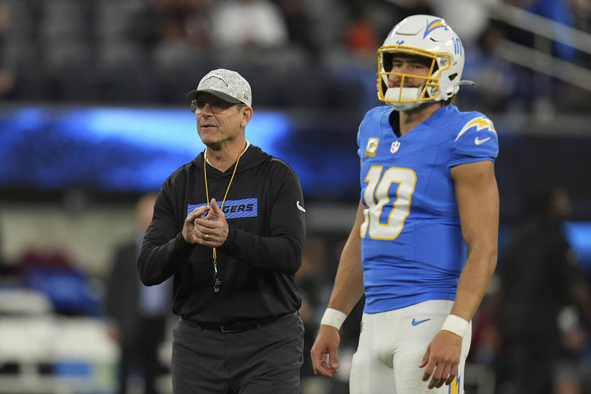 Los Angeles Chargers head coach Jim Harbaugh talks with quarterback Justin Herbert before an NF ...