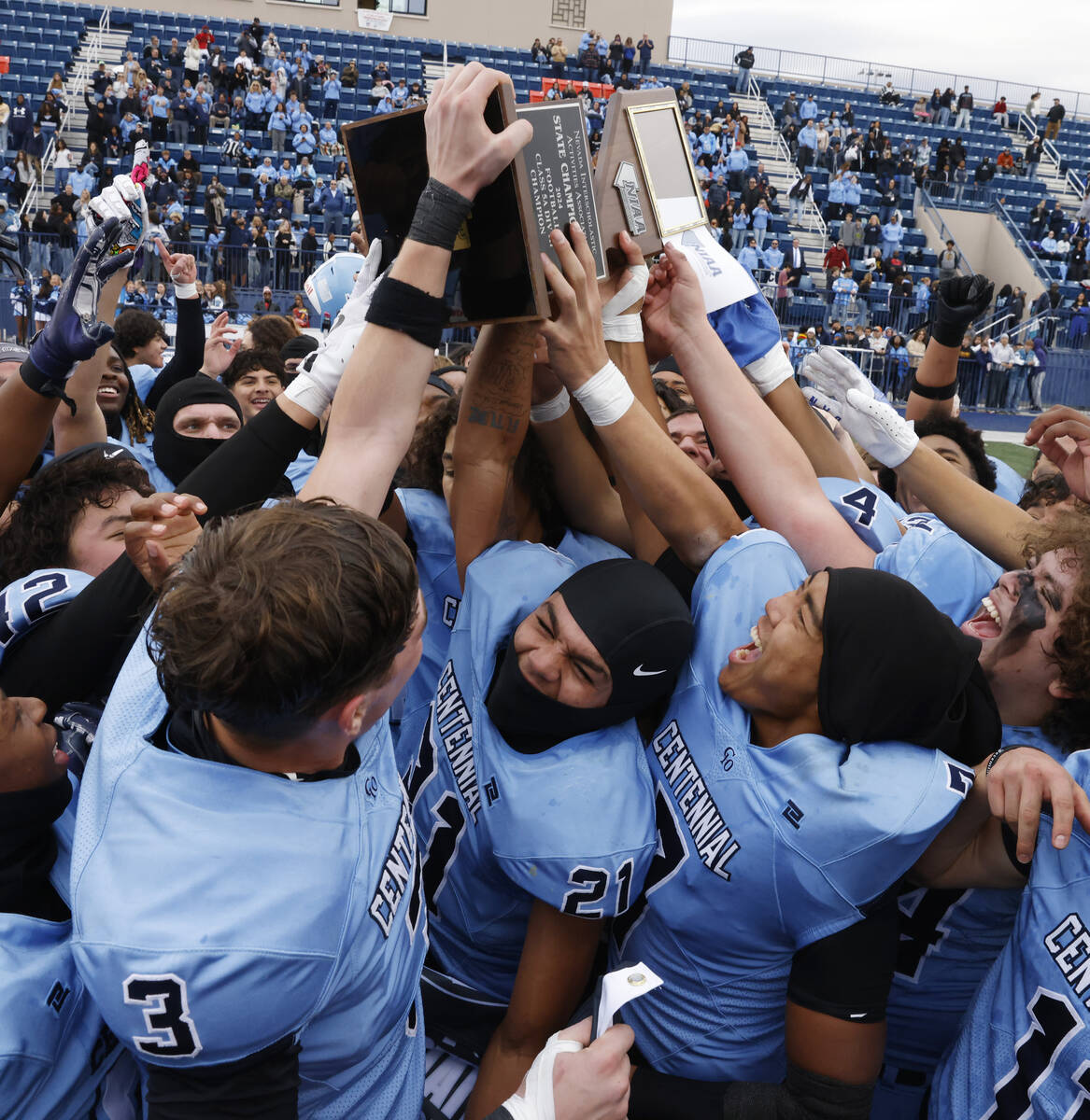 Centennial High players celebrate their Class 5A Division III football state championship win a ...