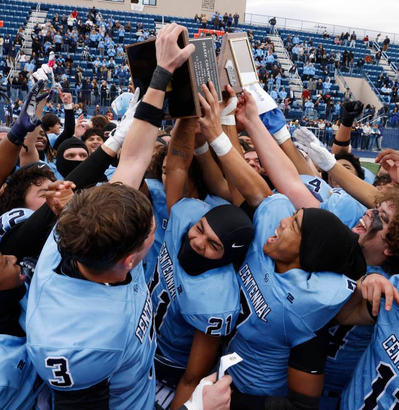 Centennial High players celebrate their Class 5A Division III football state championship win a ...